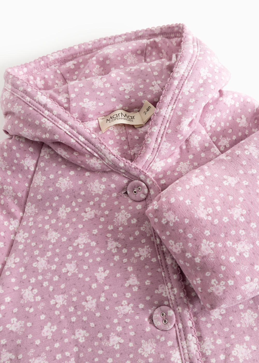 Pink jumpsuit with hood, snap closure and small white flower print.