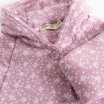 Pink jumpsuit with hood, snap closure and small white flower print.