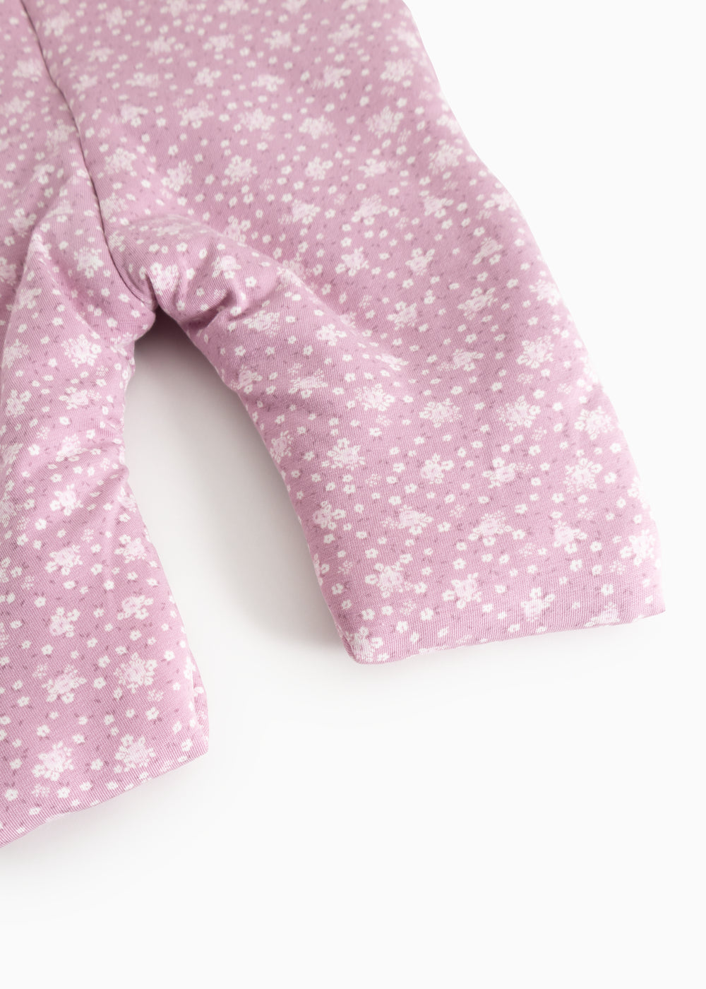 Pink jumpsuit with small white flower print, long legs and sleeves