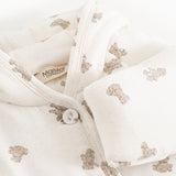 White dress with beige teddy bear print, hood and button closure at the neckline.