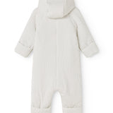 White dress with small black dots, hood at the back and long pant legs.