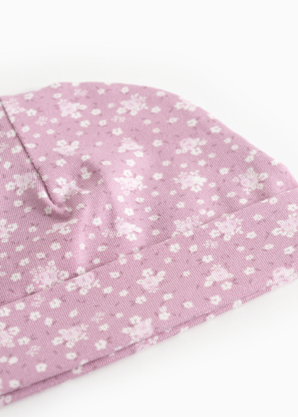 Pink baby onesie cap/hat with small white flowers and a sweet detail at the top