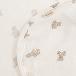 Plush blanket with teddy bear print and fabric label on the curved edge