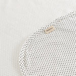 Carpet with small black dots and a beige label on the corner