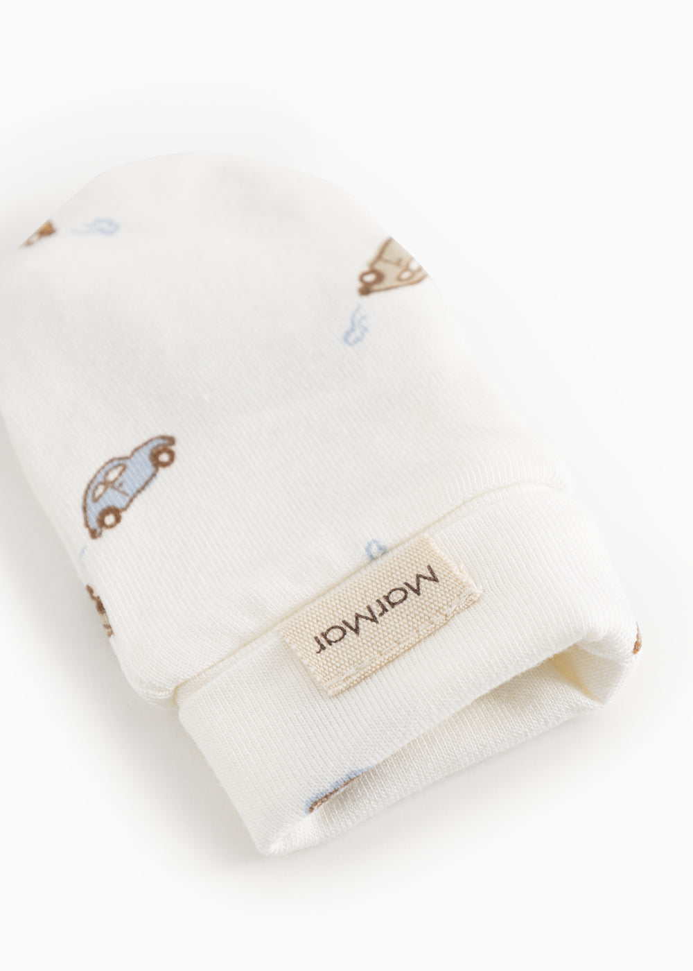 White baby plush with car print and label on the cuff.
