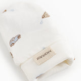 White baby plush with car print and label on the cuff.