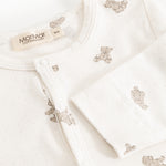 Off‑white blouse with teddy bear print, snap button closure at the neckline.