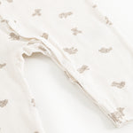 Off-white jumpsuit with teddy bear print, leg openings with snap buttons