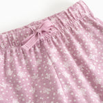 Pink baby pants with elastic waistband and front knot, pattern of small flowers.