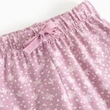 Pink baby pants with elastic waistband and front knot, pattern of small flowers.