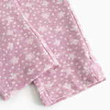 Pink pants legs with small flowers in a tight pattern and a straight seam at the knee.