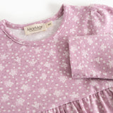 Details of a pink dress with floral print, round neckline, and pleated bust.