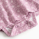 Pink dress with floral print and printed stitching at the bottom, close-up.