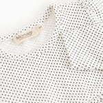 The dress's neckline and label, white with small black dots.
