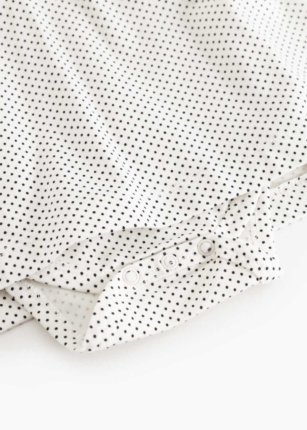 Button closure with cuff on white dress with small black dots