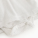 Button closure with cuff on white dress with small black dots