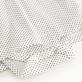 Button closure with cuff on white dress with small black dots