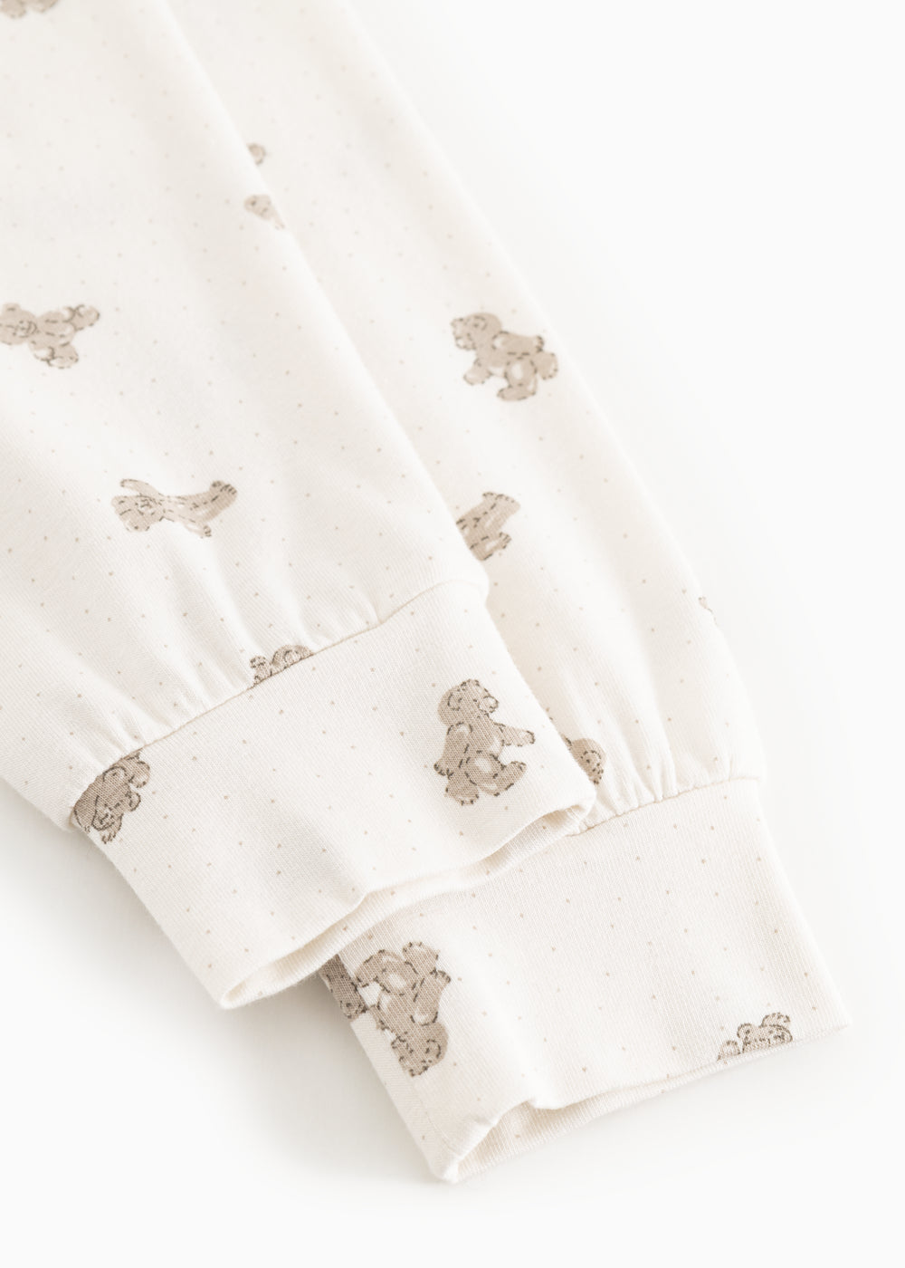 White teddy bear sweatshirt with teddy bear print at the cuff and hem.
