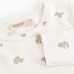 Offwhite pajamas top with round neck, teddy bear print and label.