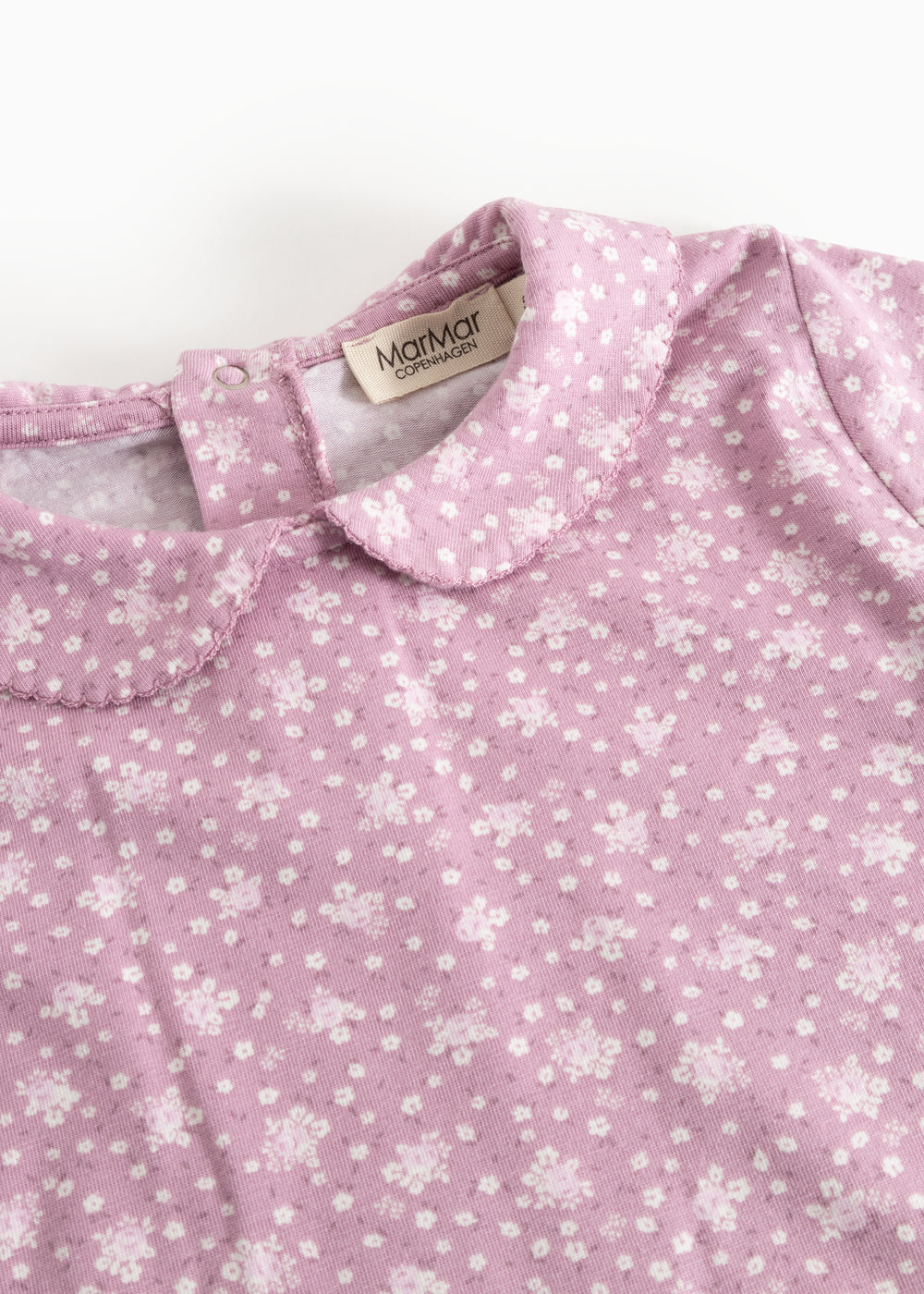 Pink long-sleeve T-shirt with small white flowers and a collar edge at the neck.
