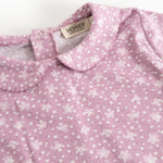 Pink long-sleeve T-shirt with small white flowers and a collar edge at the neck.