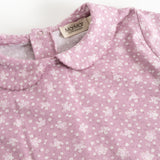 Pink long-sleeve T-shirt with small white flowers and a collar edge at the neck.