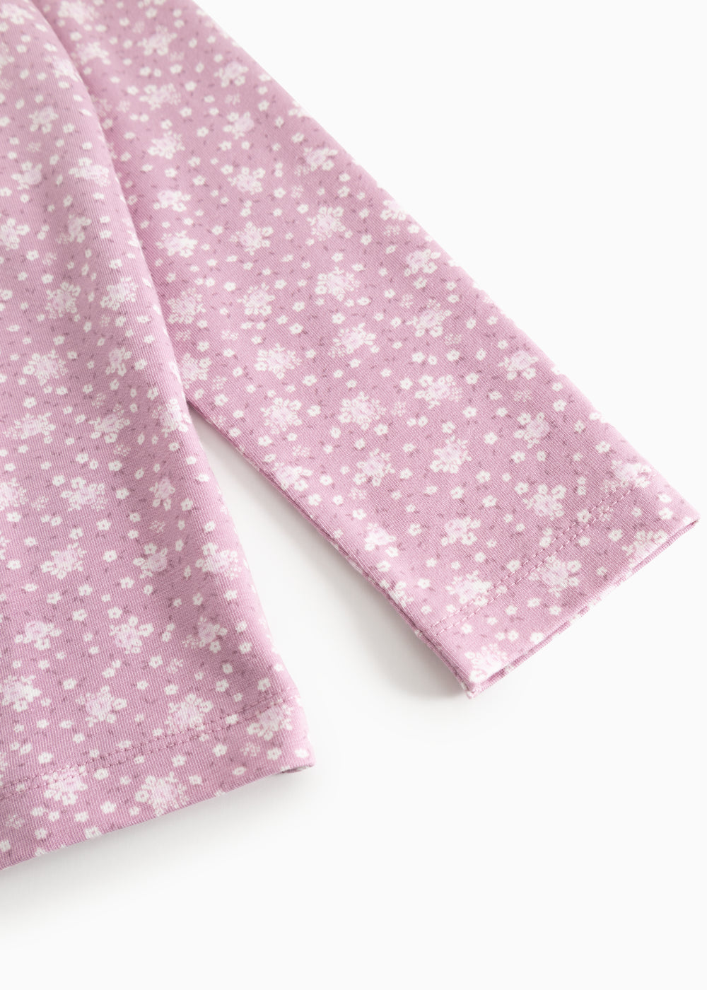 Pink long-sleeve T‑shirt with small white flowers, view from the sleeve and front.