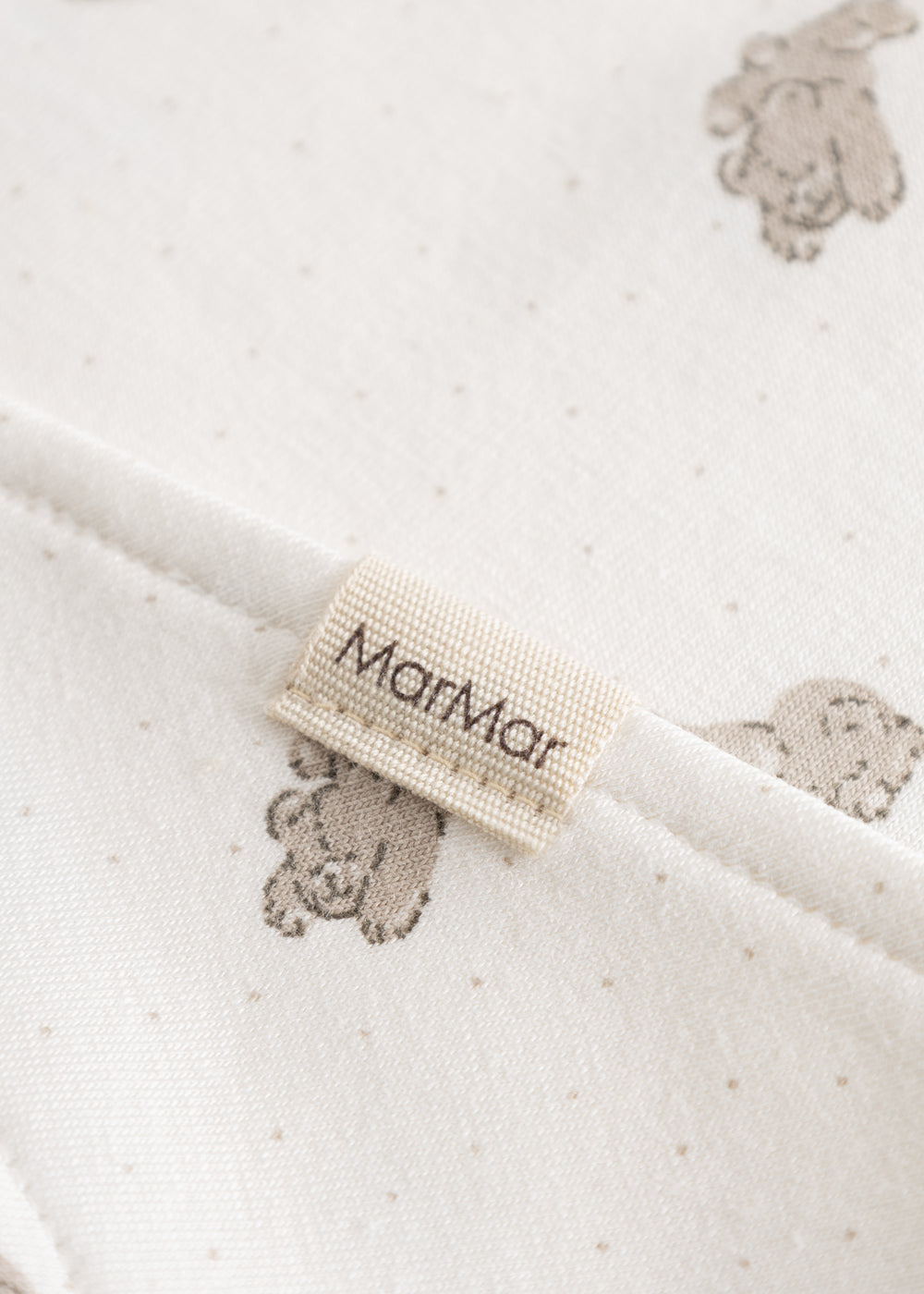 Plush teddy bear print and text label at the collar.