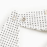 White triangular plush toy with small black dots and metal snap buttons