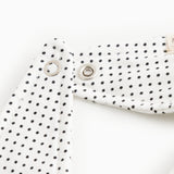 White triangular plush toy with small black dots and metal snap buttons