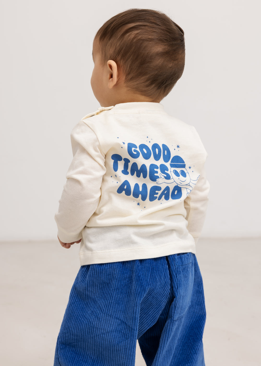 Cream long-sleeve blouse with a blue "Good Times Ahead" print on the back.