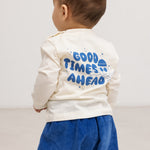 Cream long-sleeve blouse with a blue "Good Times Ahead" print on the back.