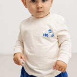 Long-sleeve blouse in cream with a blue "Hello" print on the chest.
