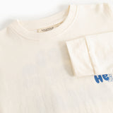 Cream long-sleeve blouse with round neck and blue "Hello" print on the right side.