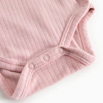 Pink ribbed bodystocking with snap buttons in the crotch and a hem at the sleeve.