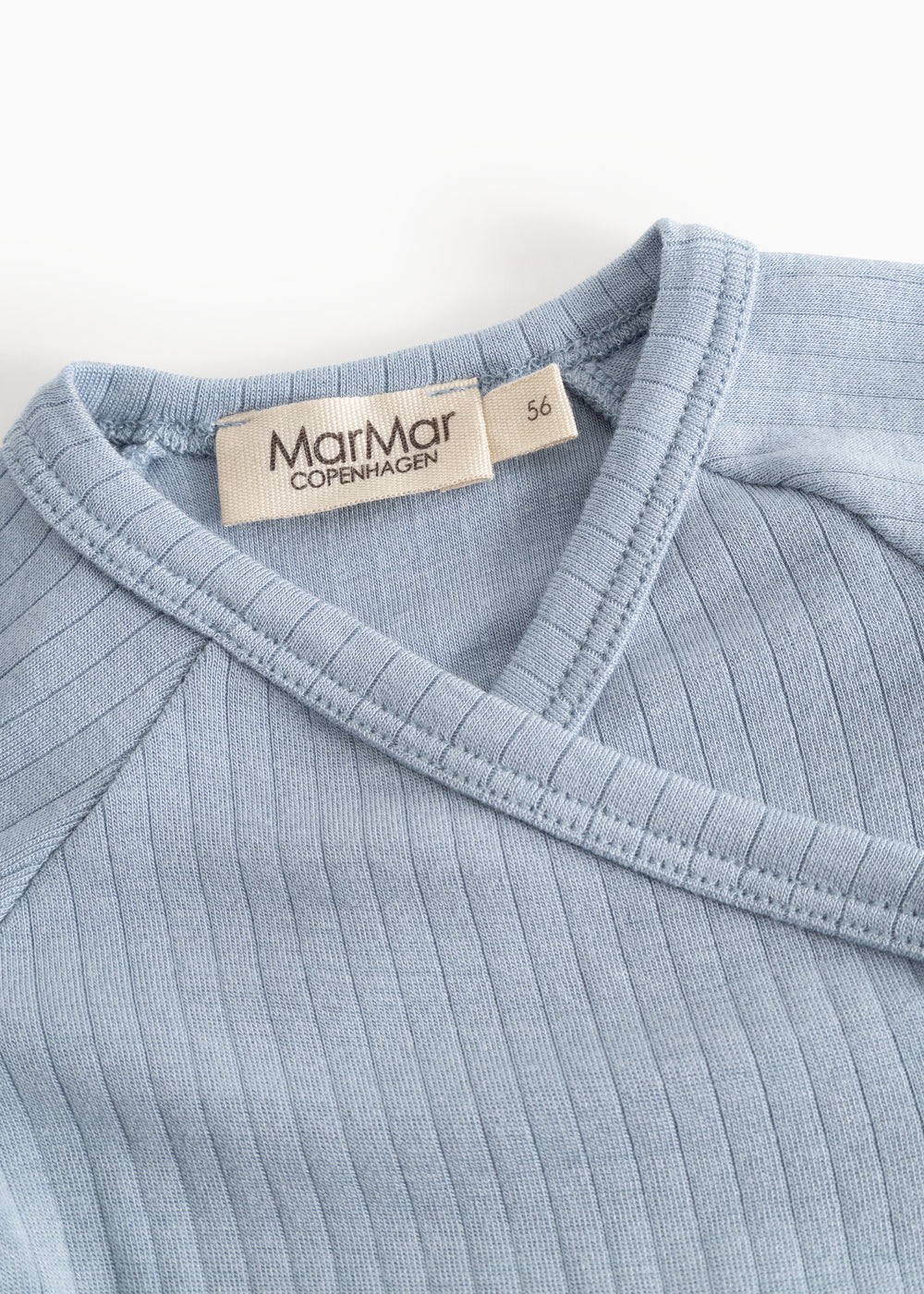 Light blue ribbed long-sleeve blouse with a wrap neckline and brand.