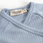 Light blue ribbed long-sleeve blouse with a wrap neckline and brand.