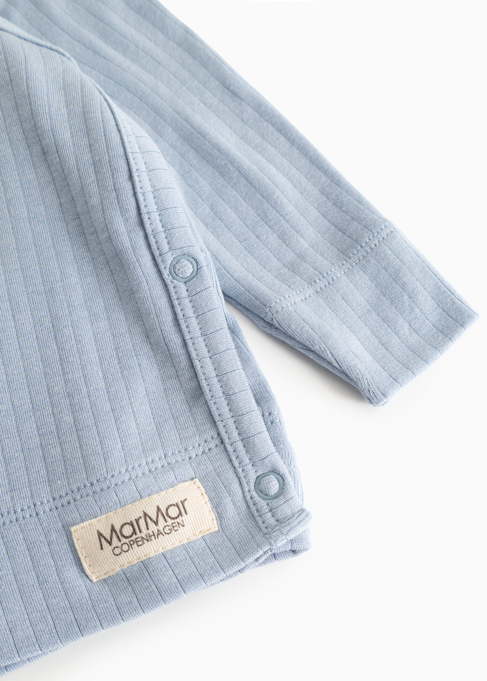 Light blue long-sleeve blouse with rib pattern and snap buttons at the seam.