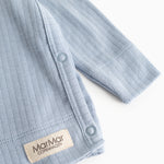 Light blue long-sleeve blouse with rib pattern and snap buttons at the seam.