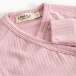 Pink jumpsuit with ribbed collar and label at the neckline.