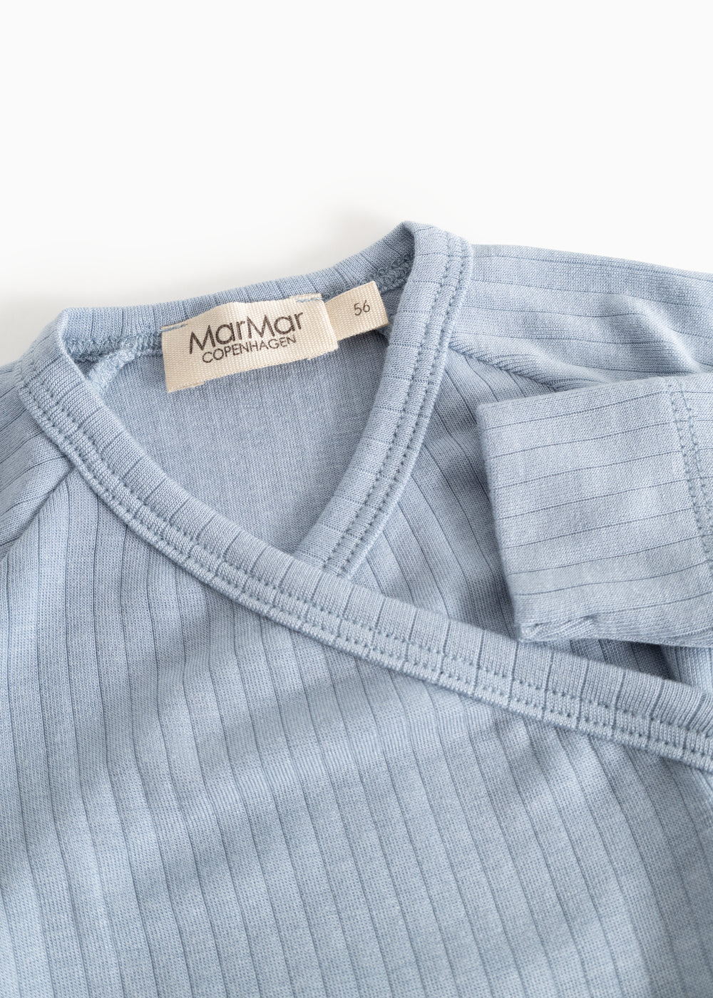 Light blue jumpsuit with V-neck and ribbed trim; logo label at the neck.