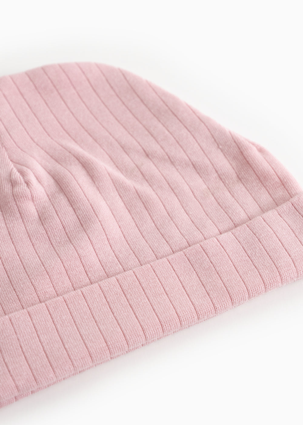 Pink ribbed baby hat with trim and visible stripes.