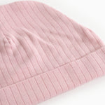 Pink ribbed baby hat with trim and visible stripes.