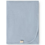 Alida rug in light blue, folded square with rounded edge and visible brand label.