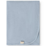 Alida rug in light blue, folded square with rounded edge and visible brand label.