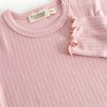 Pink bodystocking with ribbing, round neckline and visible pressure buttons at the shoulder.