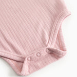 Pink, knitted long-sleeve bodystocking with snap-button closure at the leg openings.