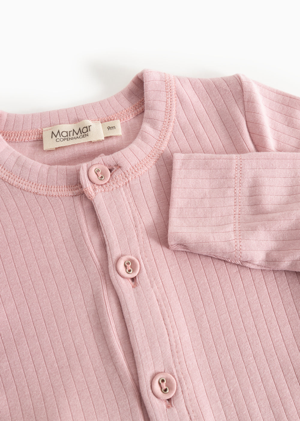 Pink baby jumpsuit with round neck, snap closure, and Mattmar brand at the collar.