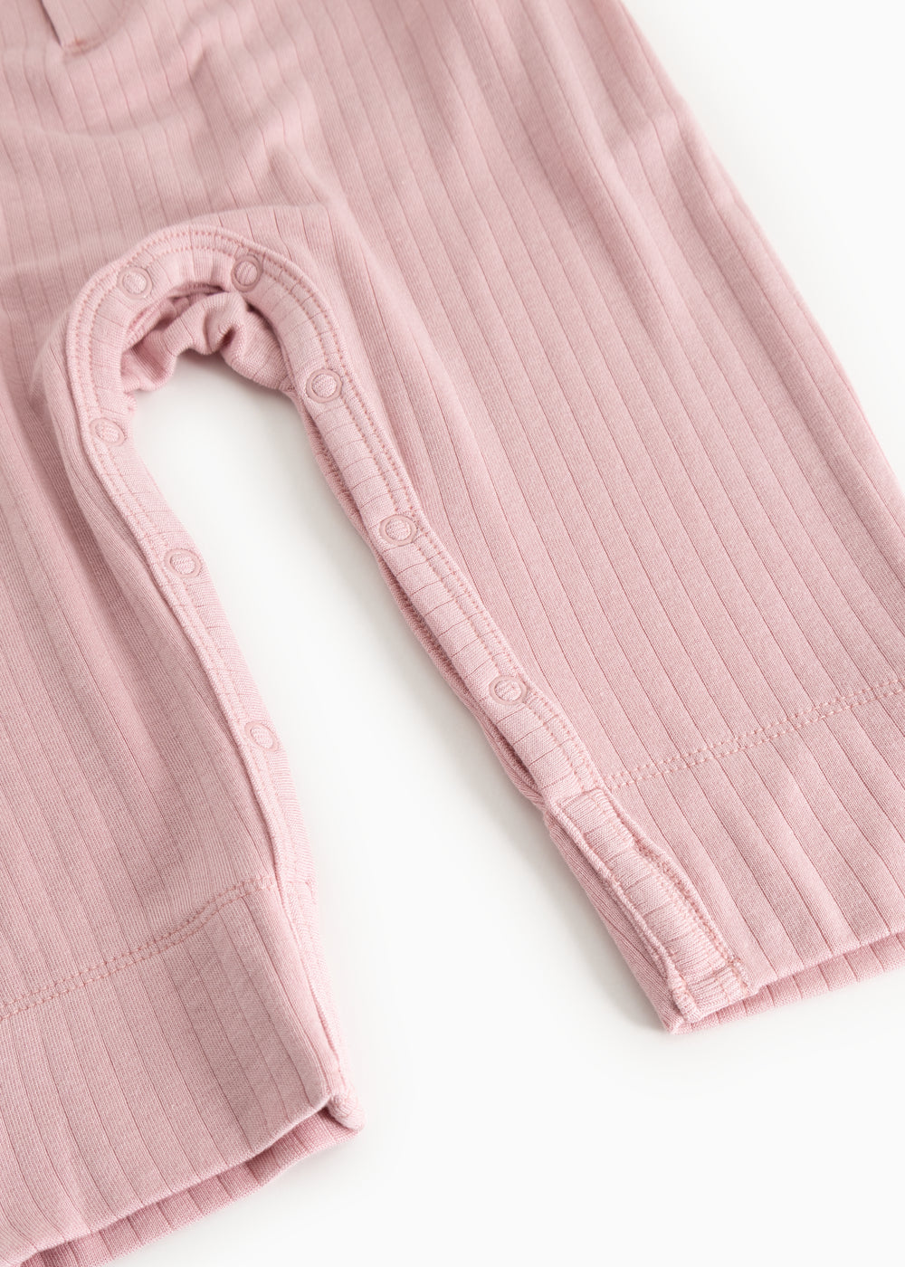 Pink baby jumpsuit with long sleeves and snap button closure at the leg opening.