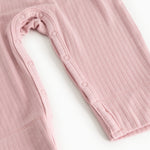 Pink baby jumpsuit with long sleeves and snap button closure at the leg opening.